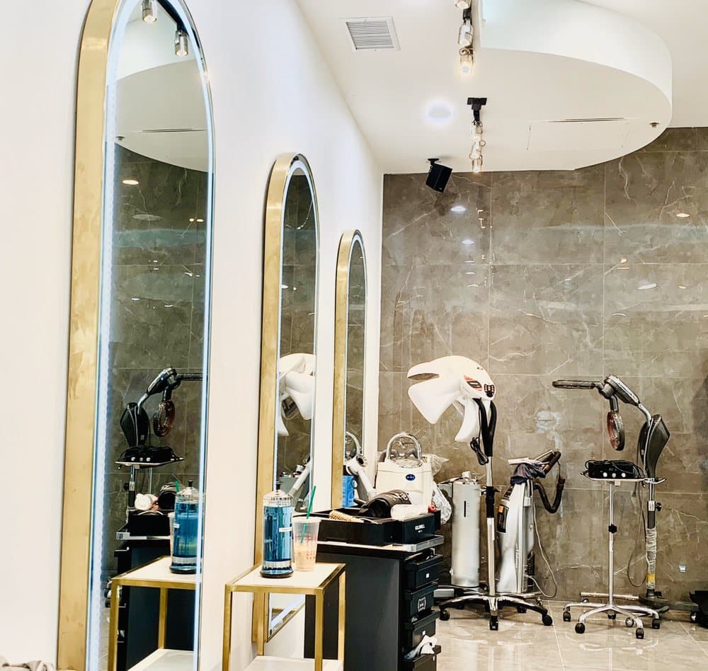 Gold arched mirrors lining a marble wall at InStyle