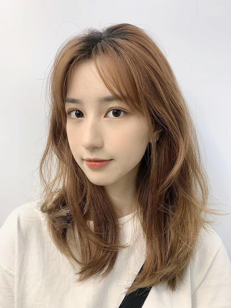 Caramel blonde waves with curtain bangs